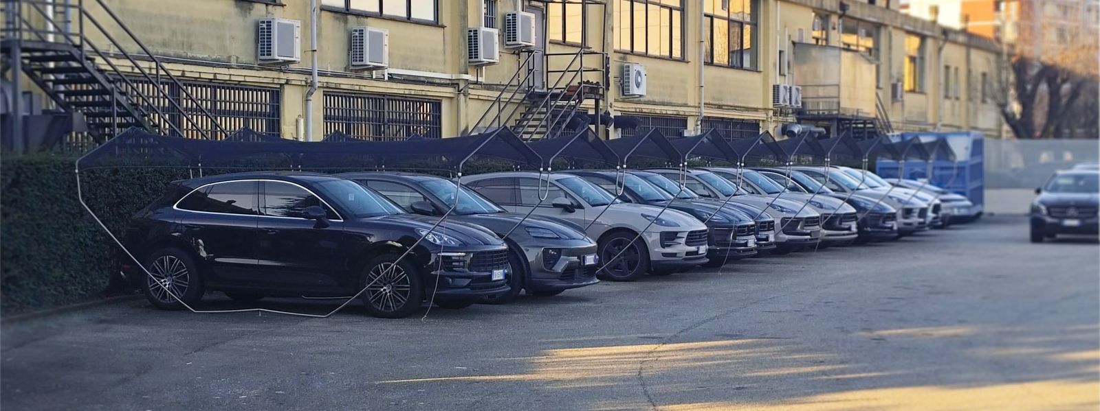 Rangée de Porsche protégées par une structure anti-grêle Icestopper sur un site de concession